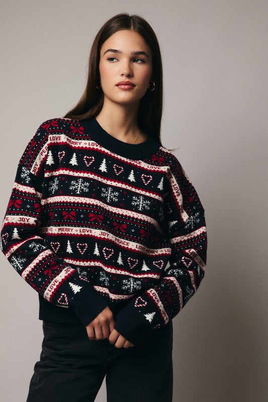 Dark navy Christmas sweater with Peace, Joy, Love, Merry lettering and festive holiday graphics – bows, snowflakes, candy canes, and Christmas tree