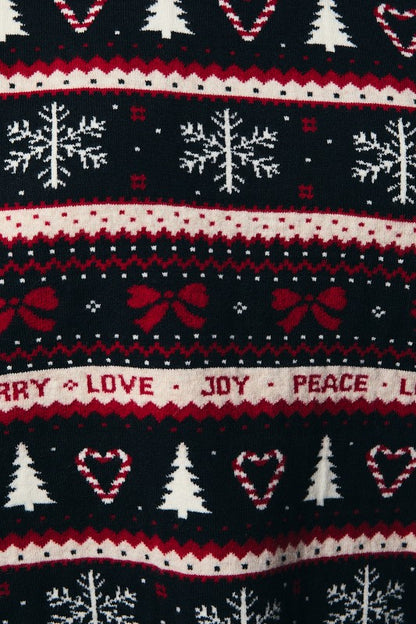 Close-up of colorful holiday design on Christmas sweater featuring bows, candy cane hearts, snow, and tree motifs